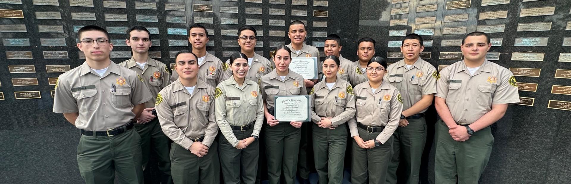 Cadets With Certificates by Memorial Wall